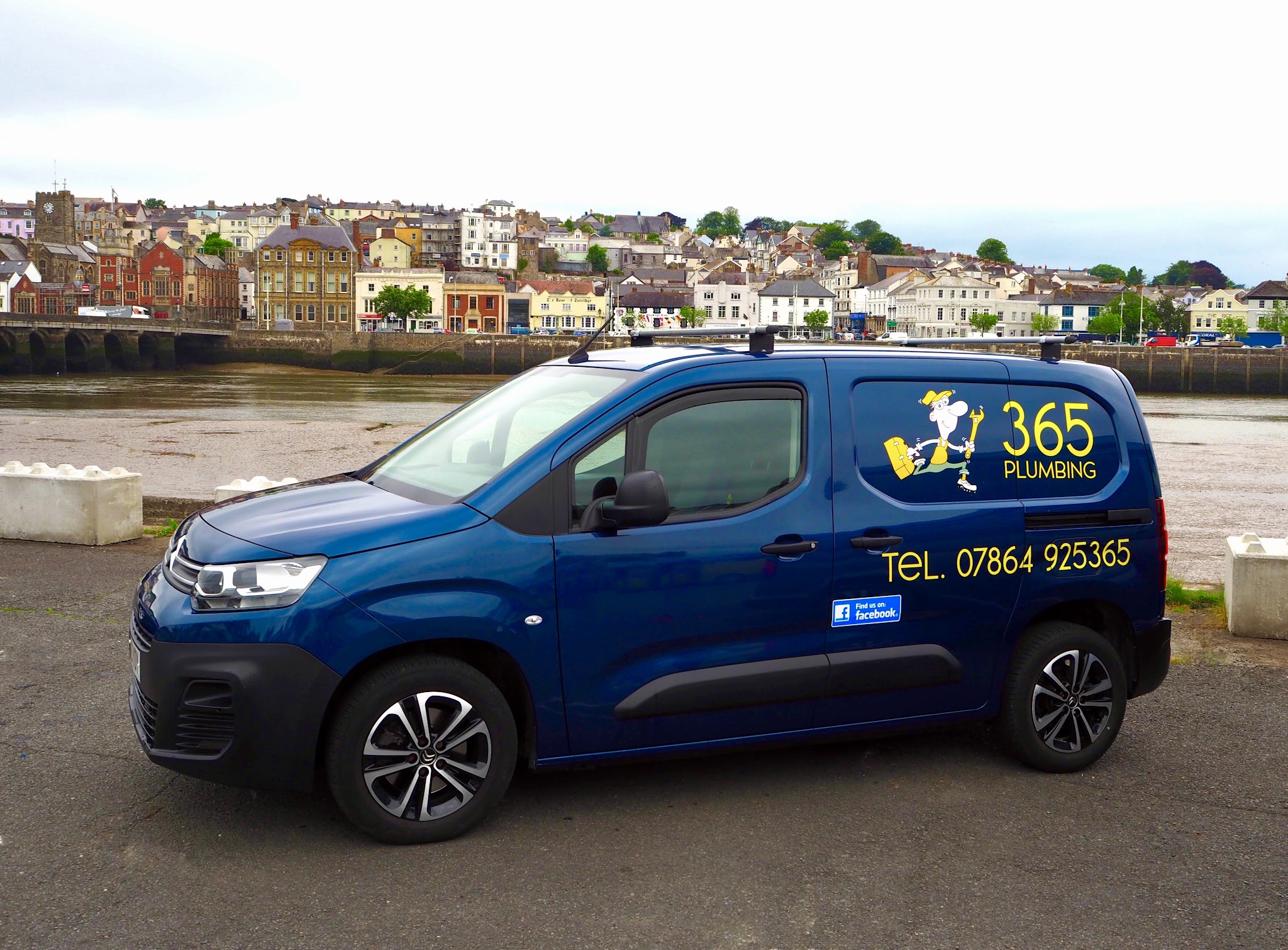 The navy 365 Plumbing van parked on the quay in Bideford with the town across the river